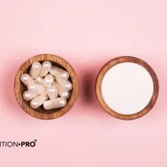 Dos cuencos de madera sobre fondo rosa: uno con cápsulas y otro con polvo blanco. Información sobre colágeno marino, efectos secundarios y beneficios.