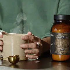Manos sostienen taza humeante junto a un frasco de colágeno bovino, mostrando de qué está hecho el colágeno.
