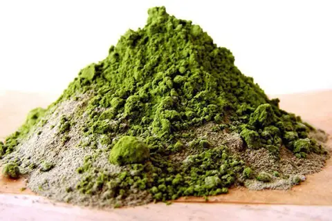 Montículo de arcilla verde en polvo, ideal para tratamientos de belleza y desintoxicación. Descubre los arcilla verde beneficios.