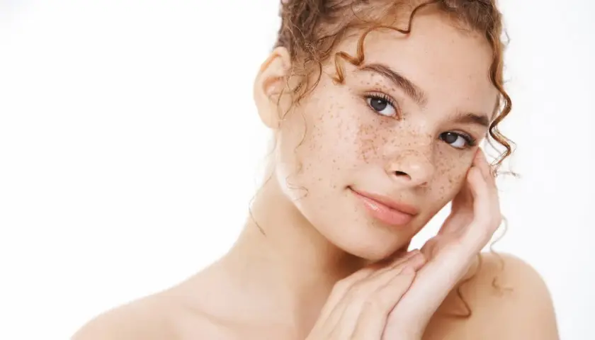 Joven con pecas en la cara, su significado es belleza natural y autenticidad.