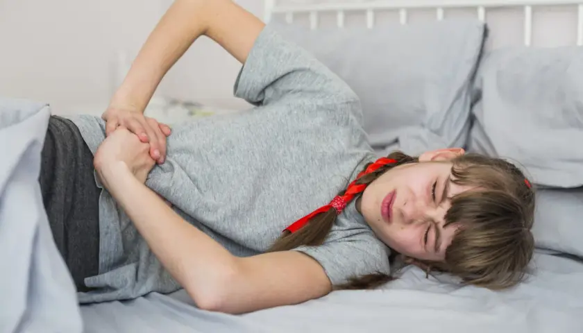 Niña con dolor abdominal, posible síntoma de rotavirus en niños.