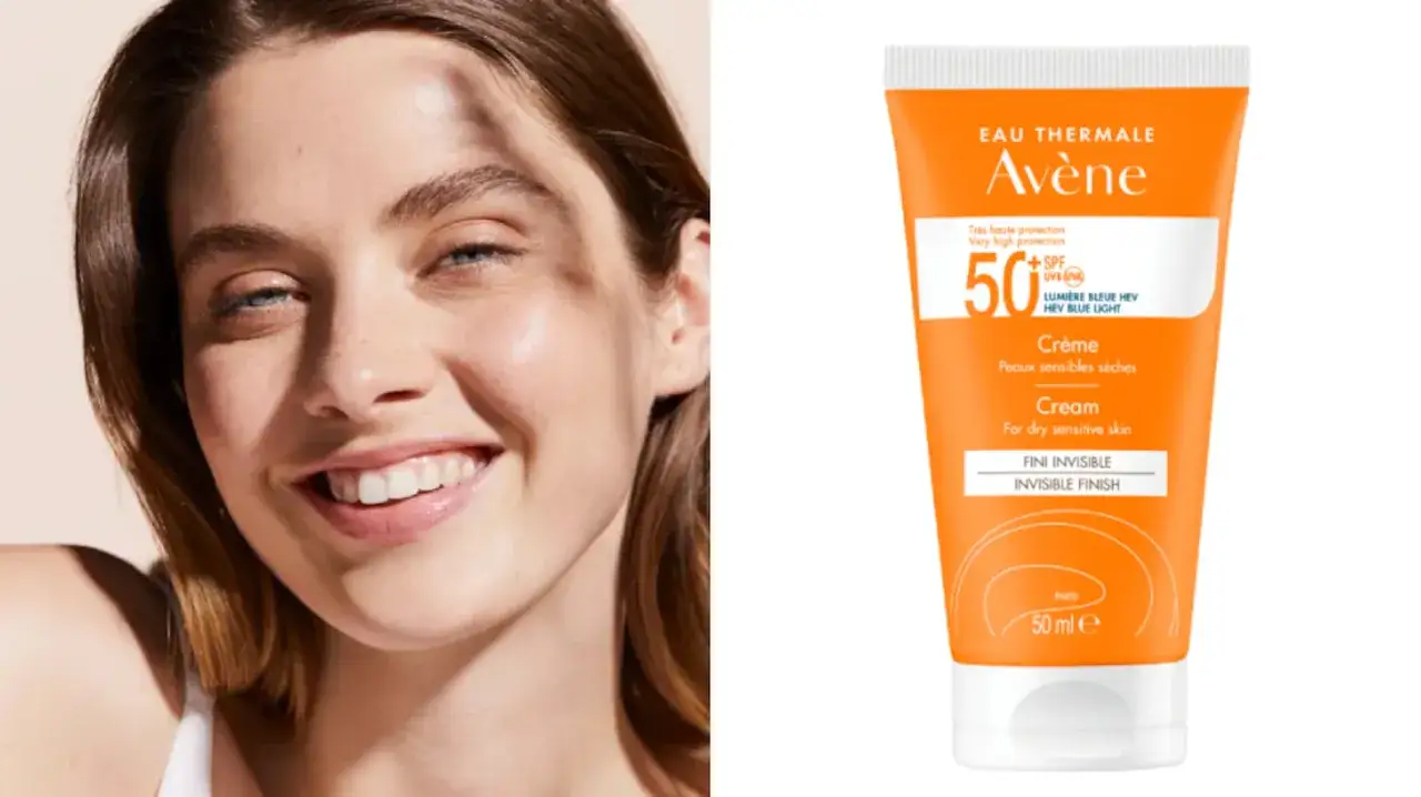 Una mujer sonríe mientras se muestra un tubo de protector solar Avène SPF 50. Este protector solar hidrata la piel, dejándola suave y protegida.